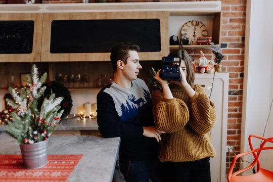 young couple is photographed hugging in the kitchen during Christmas