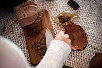 Shaman hand holding a sharp knife, chop the cacao.cacao ceremony.
