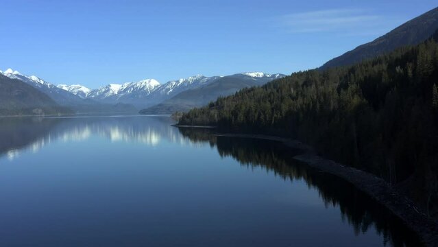 Elevated Bliss: Overlooking Slocan Lake's Sparkling Blue Beauty Encircled by Snowy Forested Peaks