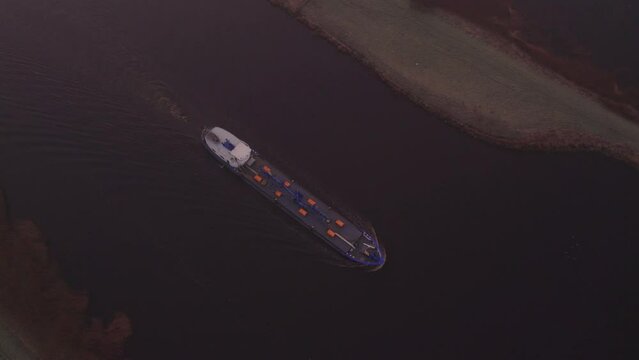 Large vessel moving past Bergum during misty morning in Burgumer Mar, aerial 4k