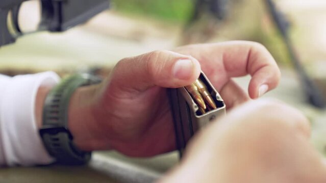 Soldier arming his rifle, adding bullets to the magazine at a shooting range