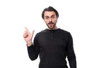 Fototapeta premium young handsome brunet european man in a black sweatshirt enthusiastically communicates an idea on an isolated white background