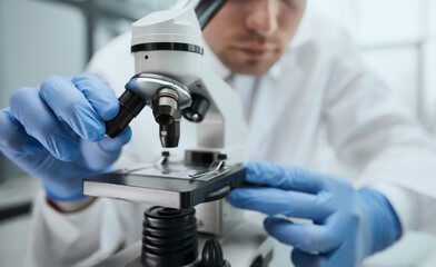 Naklejka na ściany i meble biologist explores the substance under the microscope
