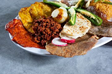 A view of a Mexican platter, featuring chorizo, cecina, tasajo, pollo.