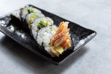 A closeup view of a plate of salmon skin roll.