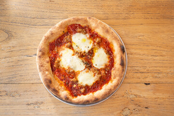 A top down view of a rustic artisan personal pizza, featuring fresh mozzarella and tomato sauce.