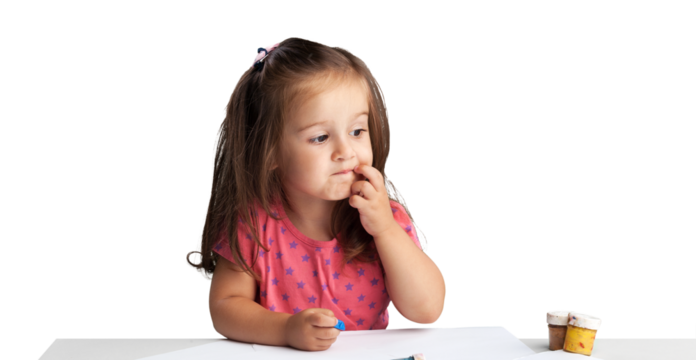 Cute little girl doing homework,writing and painting.