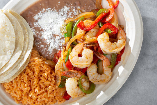 A Top Down View Of A Plate Of Shrimp Fajitas.