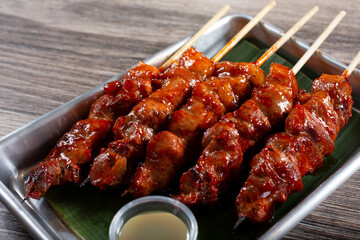 A view of a tray of BBQ pork skewers.