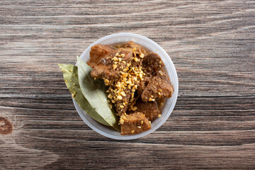 A top down view of a plastic container of pork adobo.