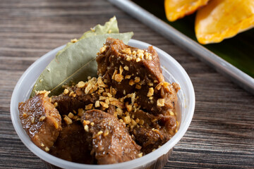 A view of a plastic container of pork adobo.