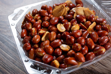 Obraz premium A view of a plastic container of Filipino style garlic peanuts.