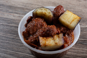 A view of a plastic container of pork binagoongan.