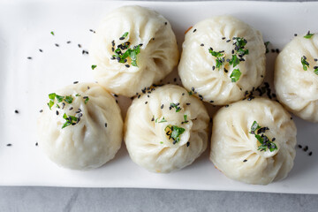A top down view of a plate of xiaolongbao dumplings.