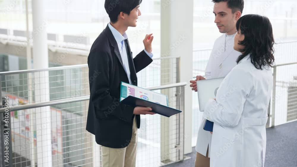 Poster a multinational group having a conversation in the lobby. people in white coats and sales staff.