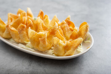 A view of a plate of cream cheese wontons.