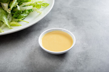 A view of a condiment cup of hot mustard.