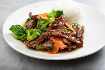 A view of a plate of beef broccoli and steamed white rice.