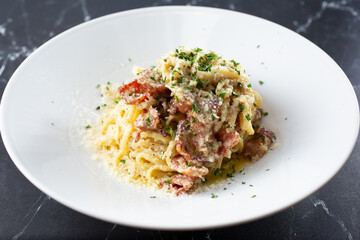 A view of a plate of pasta carbonara.