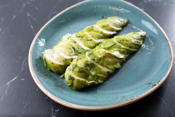 A view of a plate of sliced grilled pesto chicken.