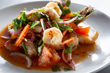 A closeup view of a bowl of tom yum seafood.