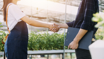 Farmer man and woman using laptop examing quality at vegetable hydroponic at greenhouse. Concept of vegetables health food. Smart farm using technology growing business hydro produce.
