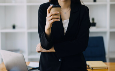 Asian Business woman using calculator and laptop for doing math finance on an office desk, tax, report, accounting, statistics, and analytical research concept