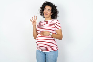 young pregnant woman wearing striped t-shirt over white background showing and pointing up with fingers number four while smiling confident and happy.