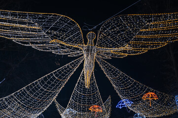 luminous decorative decor in shape of angel on street at night in winter at Christmas