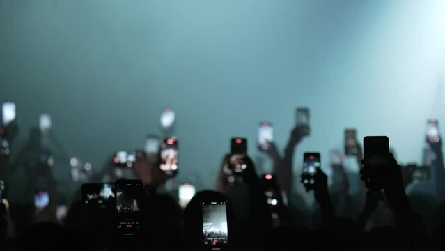 At the concert, fans hold smartphones in front of the stage, broadcast live, record videos and take photos.