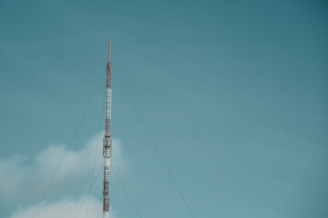 A cell phone tower with a dark sky behind it.