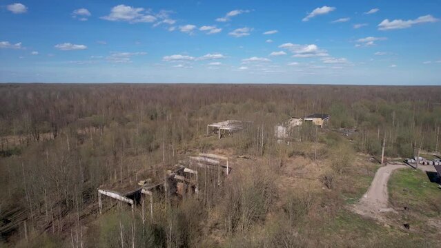 Aerial photography of abandoned and destroyed industrial premises. Drone view of abandoned buildings in the forest. From a bird's-eye view.