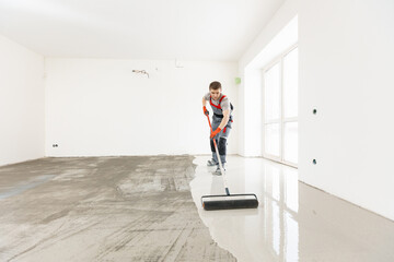 Master with needle roller for new screed concrete with mixture of cement for leveling for floors....