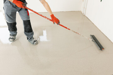 Master with needle roller for new screed concrete with mixture of cement for leveling for floors....