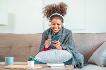 African American teenage  women sitting on sofa listening to music enjoying meditation for sleep and peaceful mind in wireless headphones relax at home.