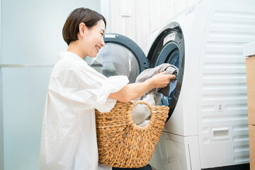洗濯をする若い女性　ライフスタイルイメージ © aijiro