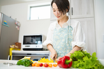 野菜を切る若い女性　料理イメージ