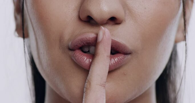 Closeup of mouth, woman and finger to lips, silence and secret with mystery, whisper and quiet hand gesture. Emoji, female person with gossip, silent expression and signal with confidential voice