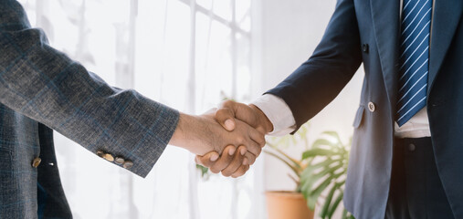 Businessmen shake hands after agreeing to start a new project successfully.