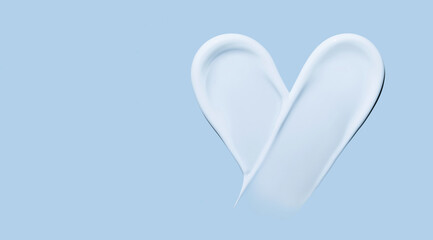 Heart shaped cosmetic smear of cream on a blue background