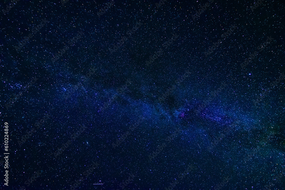 Wall mural blue starry night sky with the milky way and galaxies. astrophotography with many stars and constell