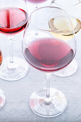 Wine glasses at a tasting. Rose, red, and white wine, drinks on a table at a winery. An assortment of wines of different colors