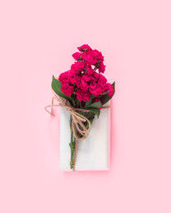 Set of wrapping paper and flowers for handmade on pink background. Homemade craft box gifts with  bouquet of red roses.