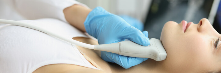 Doctor diagnoses thyroid gland on ultrasound machine closeup. Ultrasound of soft tissues of face...