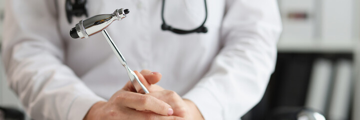 Doctor neurologist with hammer in hands in clinic. Neuropathologist is doctor who treats diseases and lesions of human nervous system