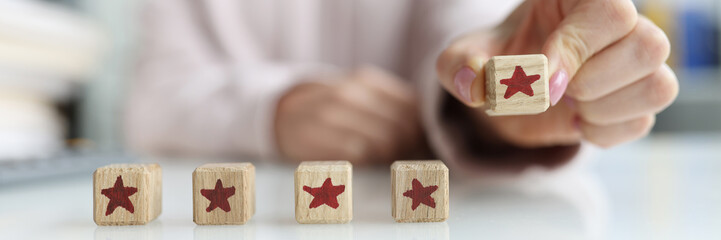 Person holds die with fifth star in hand. Recommendation and feedback concept
