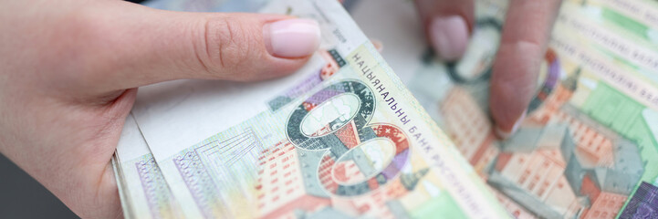 One hundred Belarusian rubles banknotes in female hands. Inflation in Belarus concept