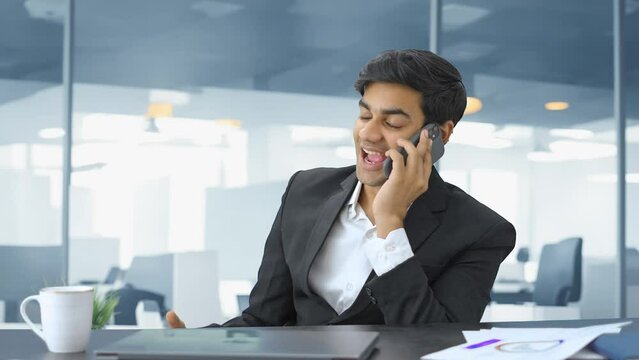 Happy Indian businessman talking on phone