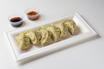 Chinese grilled dumplings with pork, chives and cabbage. pictured closeup on white table 