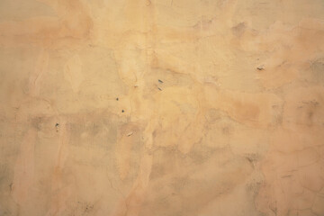 Old shabby yellow painted cracked building facade background. Concrete house exterior with grunge stucco outdoor.